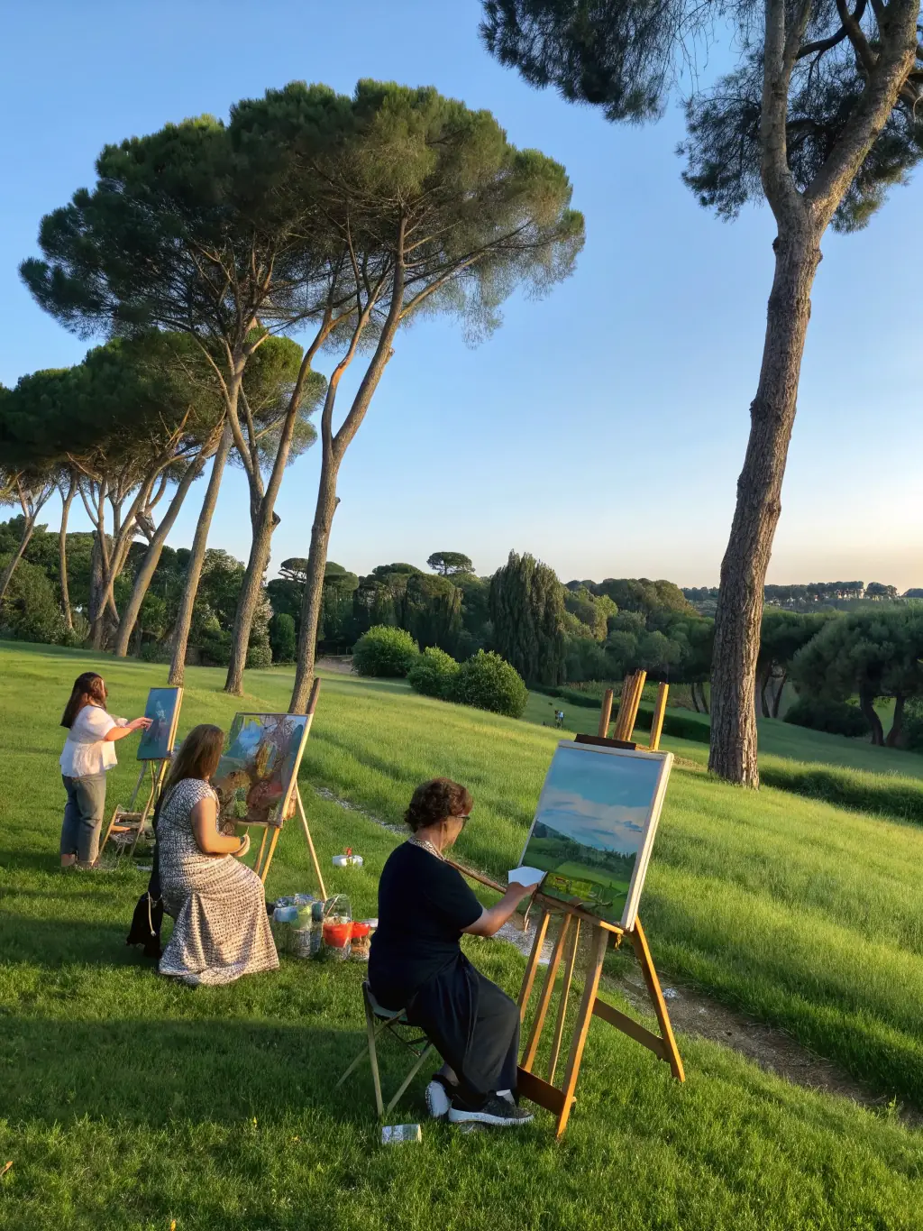 Photo d’un groupe d’artistes en résidence, travaillant en plein air dans un jardin écologique, entourés de matériaux naturels et d’installations artistiques temporaires.